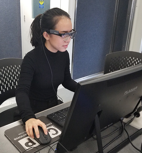 Image of a woman using a computer wearing special glasses for eye-tracking